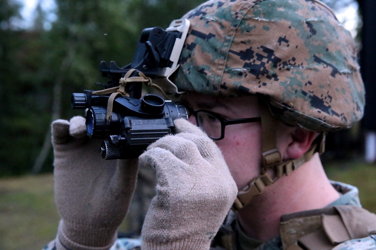 A Marine adjusting their night vision goggles.