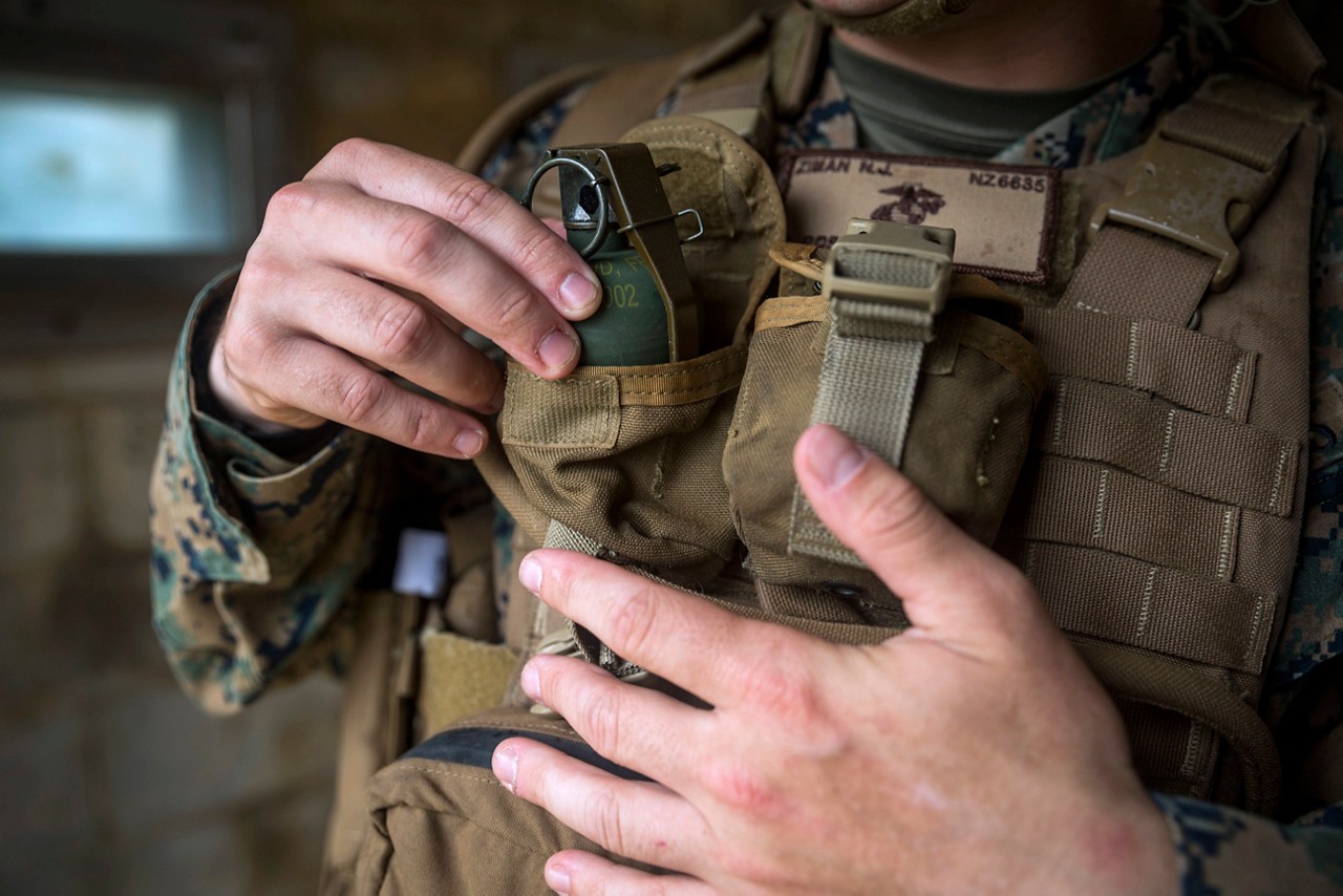 Marine placing grenade into their grenade pouch.