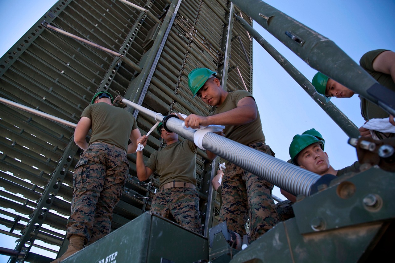 Members of the Marines ground electronics maintenance MOS doing maintenance on structure.