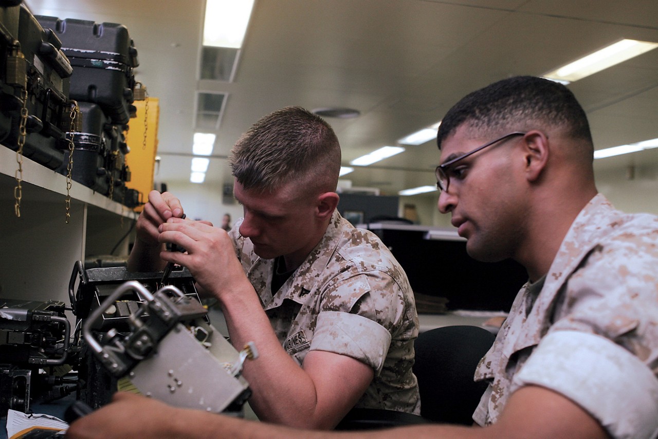 Marines with the Electronic Maintenance Company repairing communications equipment.