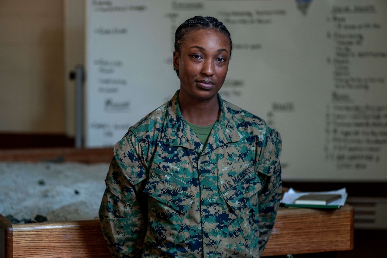  A U.S. Marine in woodland camouflage stands in a classroom. 