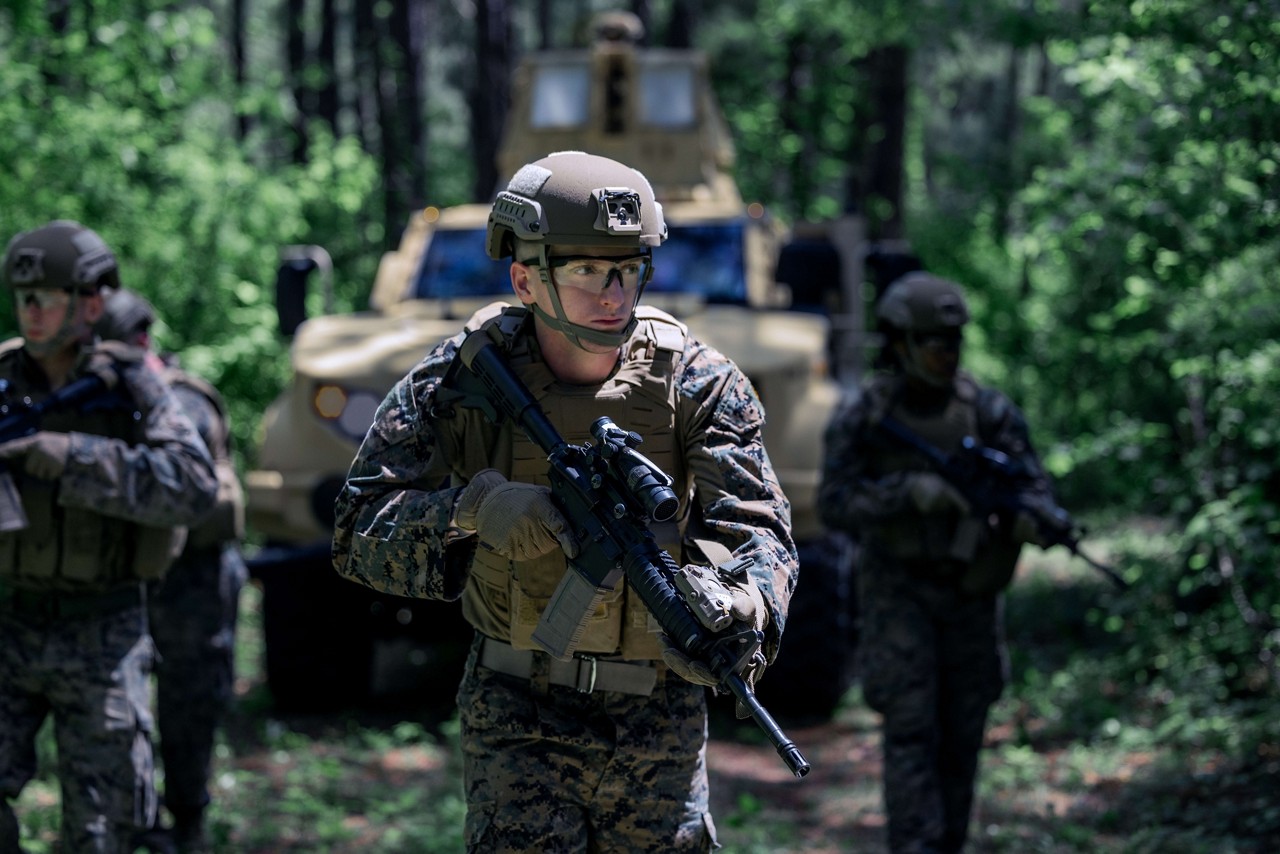  A U.S. Marine wearing woodland camouflage leads his squad on patrol in a wooded environment. 