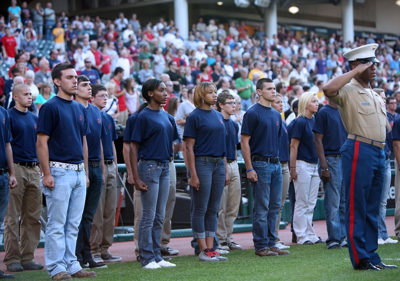 Poolees stand at attention as recruiter salutes during game.