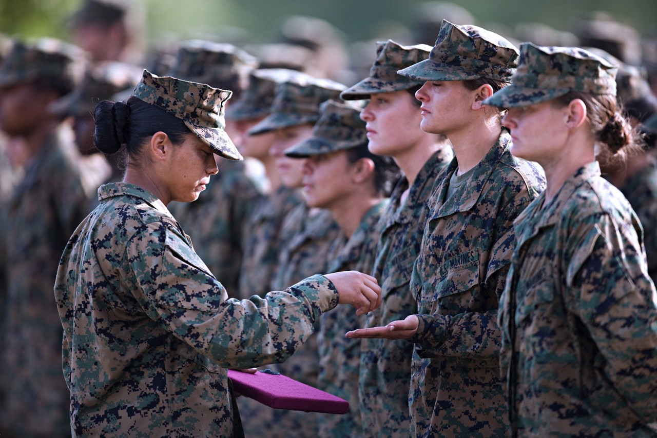 Marines receiving emblems during a graduation ceremony.