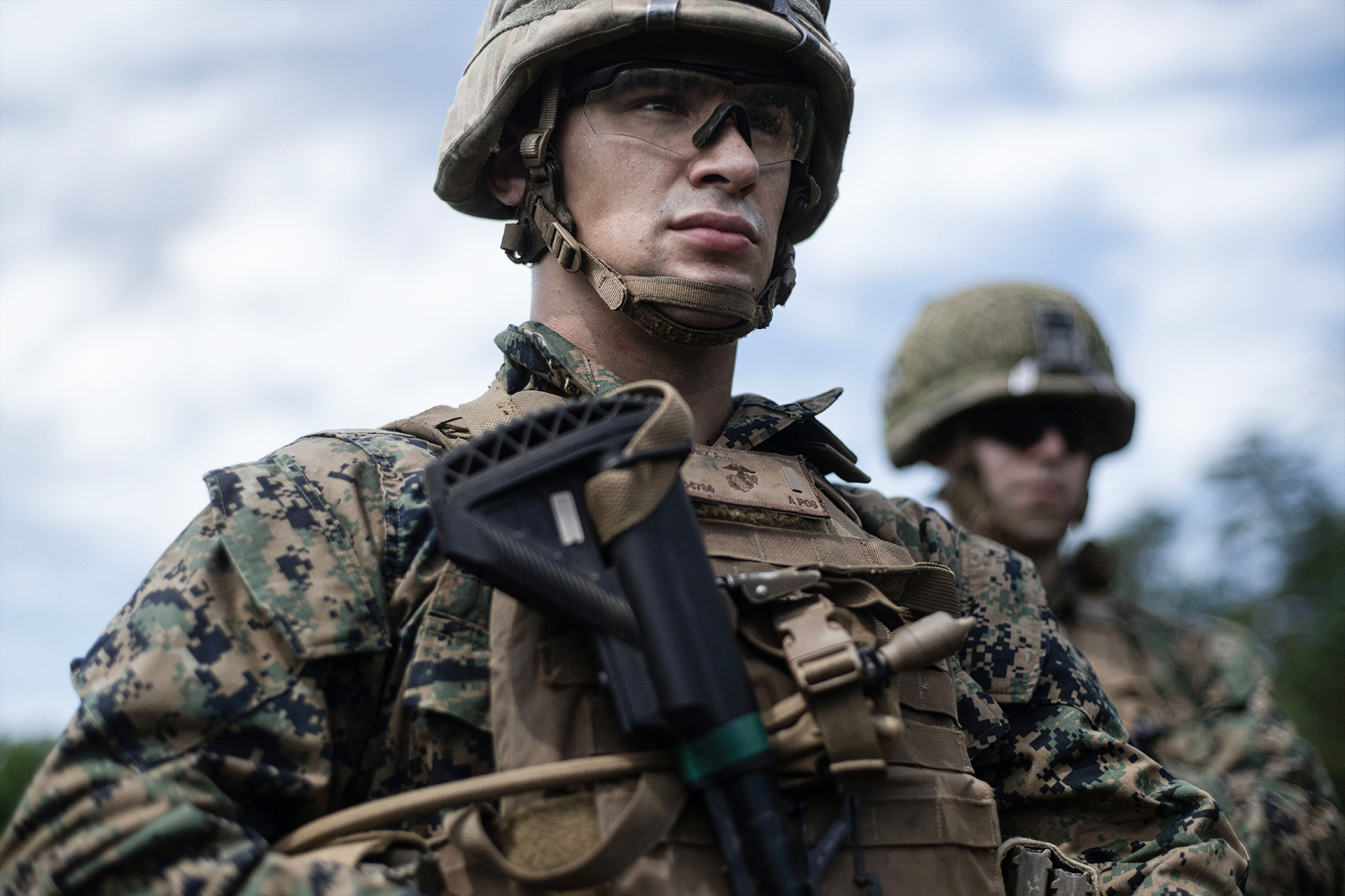 Marine officer in tactical helmet and body armor with rifle during Basic School field training exercise preparation.
