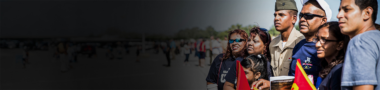 A young Marine stands with his family for a photo on the day of recruit training. 
