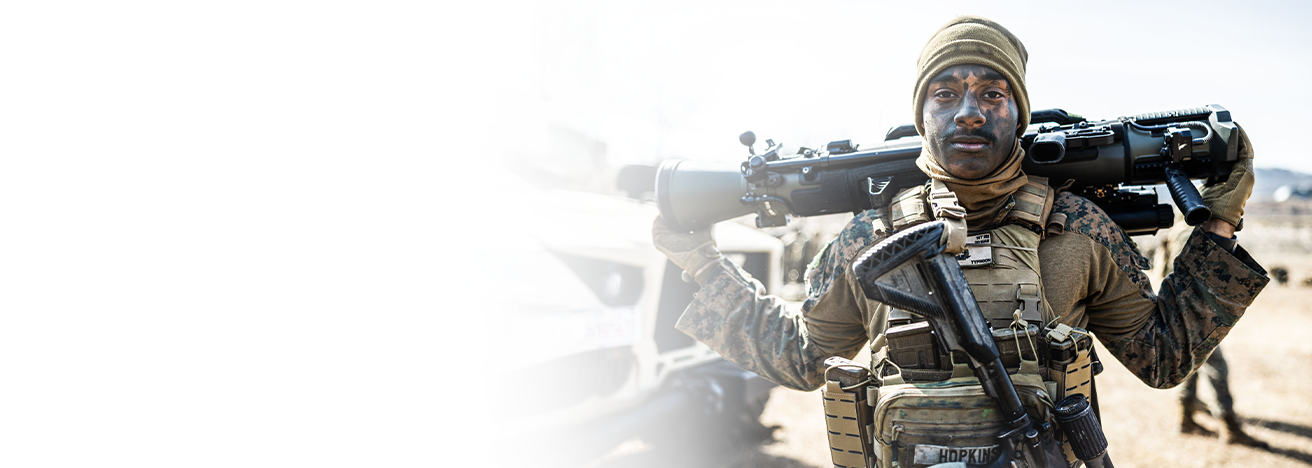 Marine carries M3E1 Multi-role Anti-Armor Anti-Personnel Weapon System on shoulders during pre-flight operations.