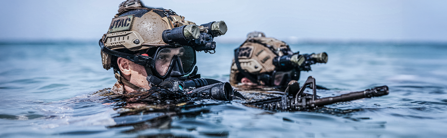 Special operations Marines conducting water training with tactical helmets and night vision equipment.