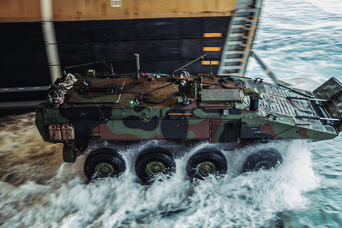 An amphibious combat vehicle disembarks into the water from the well deck of a MEU ship. 