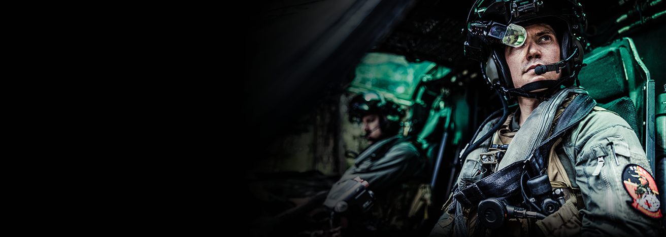 Marine aviator in flight helmet and gear piloting aircraft during mission operations.