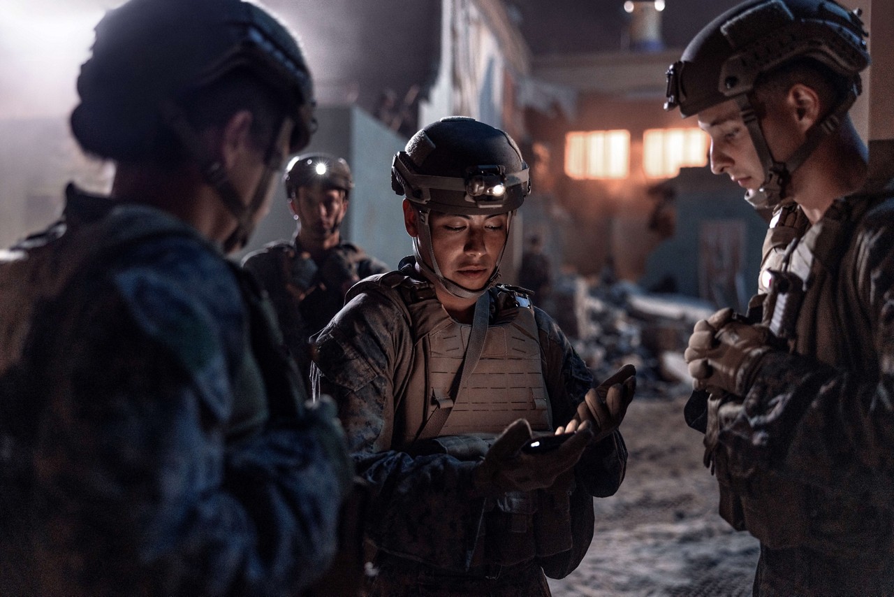 Four U.S. Marines stand in a circle reviewing a plan during a night mission. 