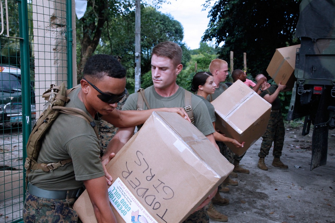 Marines delivering boxes of supplies.